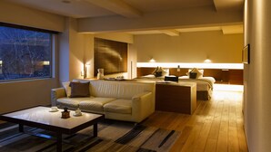 A modern living room with a sofa, coffee table, and a dining area with a table and chairs. - Bourou NOGUCHI Noboribetsu - Adult Only (Noboribetsu)