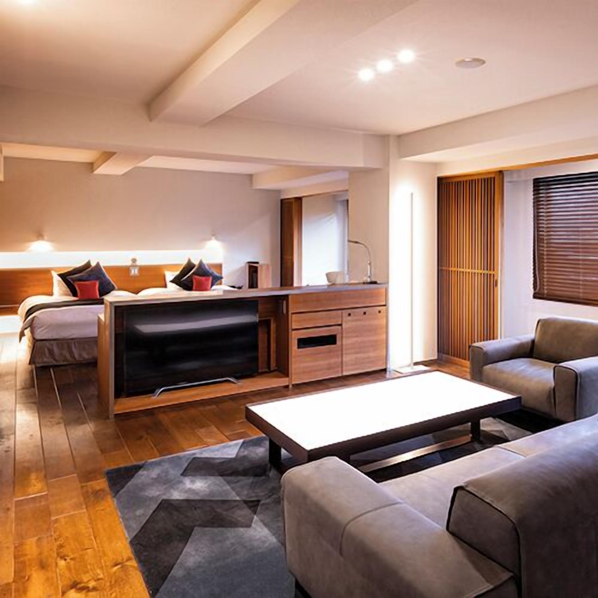 Une chambre d’hôtel moderne équipée d’un lit, d’un bureau, d’un canapé et d’une table basse.