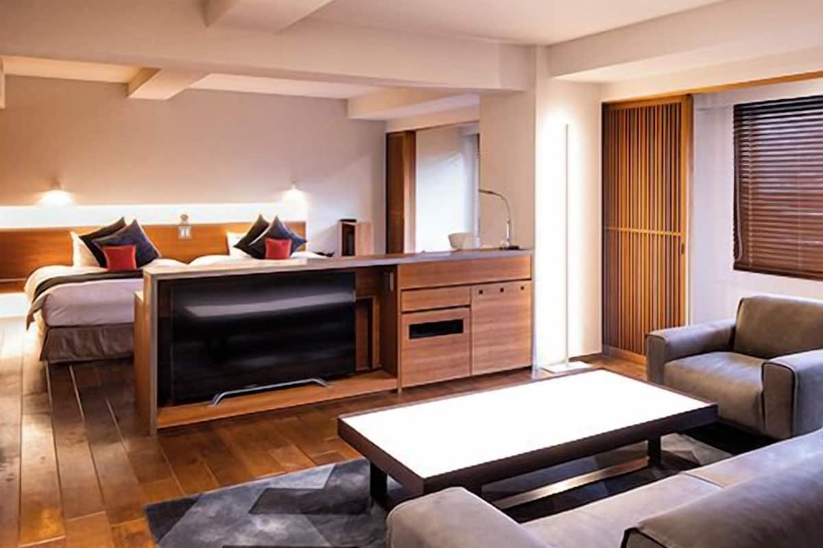 Une chambre d’hôtel moderne équipée d’un lit, d’un bureau, d’un canapé et d’une table basse.