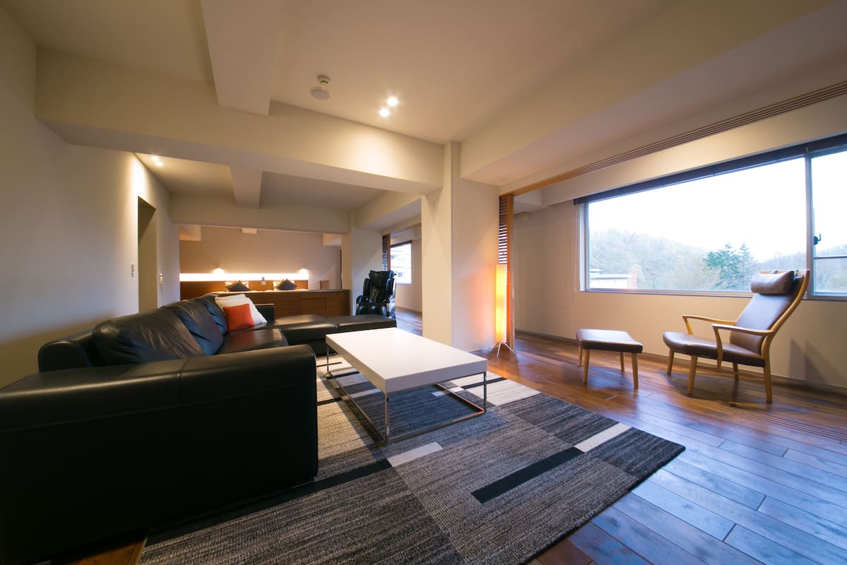 Un salon moderne avec un canapé, une table basse et une grande fenêtre.