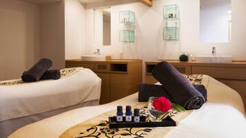 A hotel room with two beds, a vanity with a mirror, and a tray with toiletries.