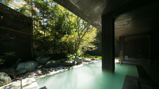 A modern outdoor pool area with a stone pathway, surrounded by rocks and greenery. - Bourou NOGUCHI Noboribetsu - Adult Only (Noboribetsu)