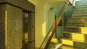 A modern interior with a staircase, a glass elevator, and a high ceiling. - Sailing Hotel (Phu Quoc)