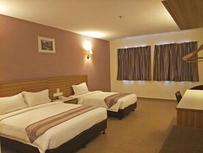 A hotel room with two beds, a desk, a chair, a telephone, and a window with curtains.
