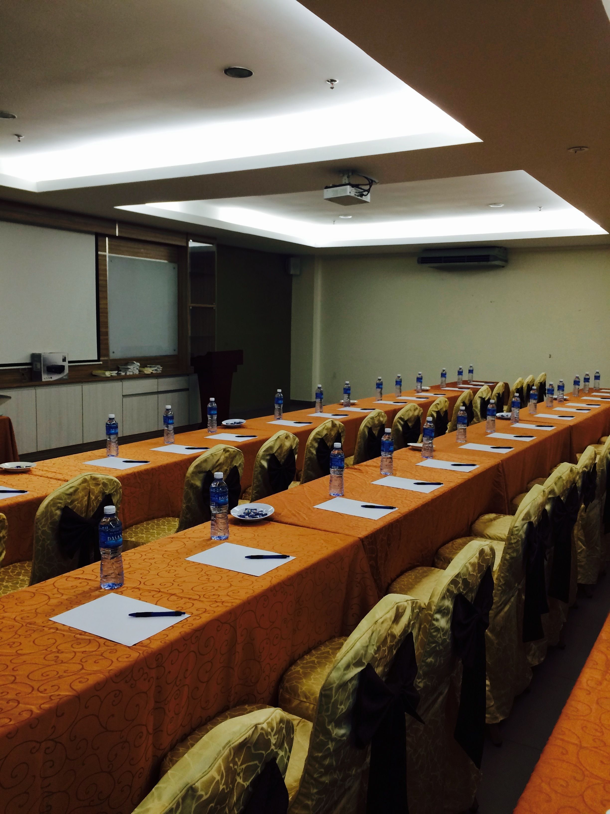 A conference room with long tables, chairs, water bottles, and nameplates.