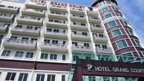 A multi-story hotel with a prominent sign reading "HOTEL GRAND COURT".