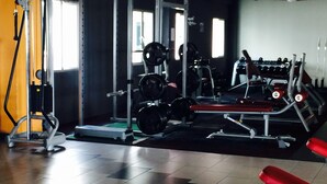A gym with weightlifting equipment, treadmills, and exercise machines.