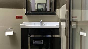 Un baño con lavamanos, espejo y un letrero que indica 'TAP TURN RIGHT'.
