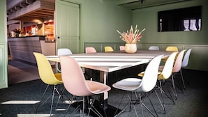 A conference room with a long table, colorful chairs, and a potted plant. - weila - dein Boutiquehotel (Arnsberg)