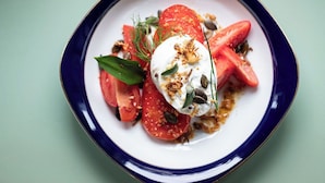A plate with a tomato salad, a dollop of cream, and some seeds. - weila - dein Boutiquehotel (Arnsberg)
