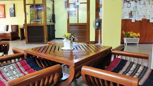 A dining area with a wooden table and chairs, a fan, and a potted plant. - Vanilla Place (Chiang Mai)