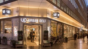 The exterior of Urban Deli with a modern facade, large windows, and a bicycle parked outside. - Hotel With Urban Deli (Stockholm)