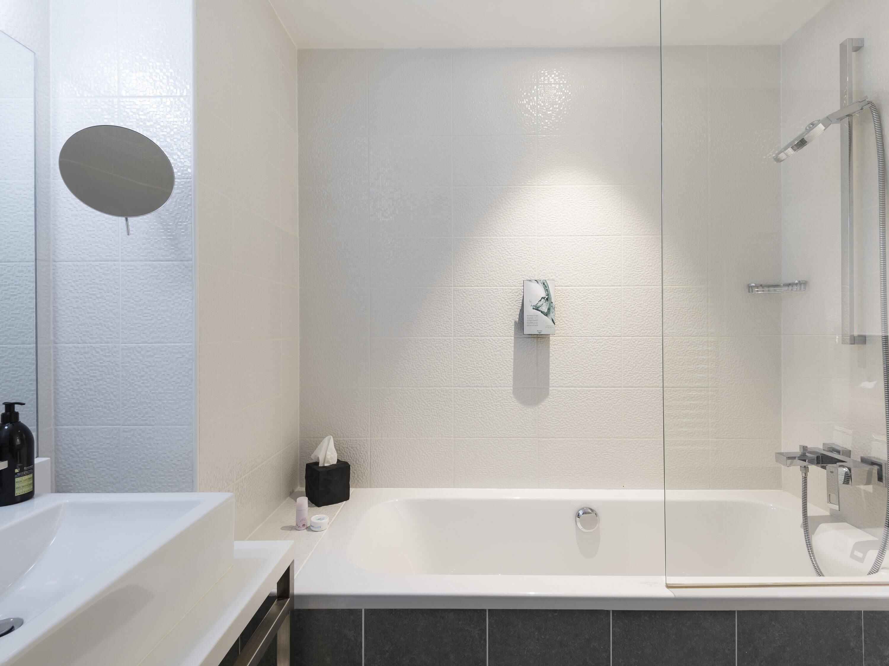 Un baño moderno con bañera, ducha y espejo.