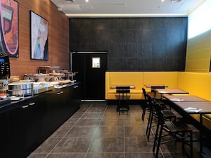 Enjoy a meal at the buffet counter, where a variety of dishes are served, or sit down at a wooden table with a cushioned bench.