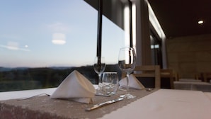 A table set for two with wine glasses and a knife, overlooking a scenic view. - Prazer da Natureza Resort & SPA (Caminha)