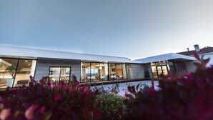 A modern building with large windows and a pool area. - Prazer da Natureza Resort & SPA (Caminha)