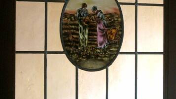 Une vitre décorée de vitraux représentant une scène pastorale.