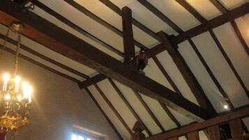 A room with exposed wooden beams and a chandelier.