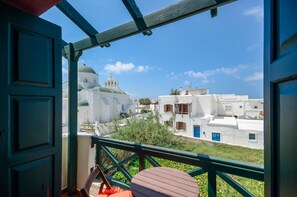 A balcony with a view of white buildings and a green dome. - Apollon Hotel (Naxos)