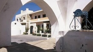 Un bâtiment blanc orné d’arches et sur lequel on peut lire l’inscription « Hôtel ».