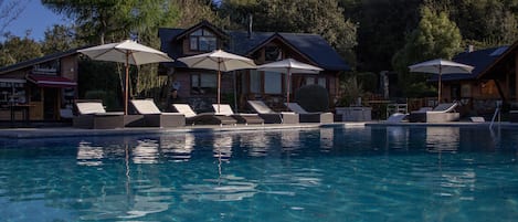 Piscine couverte, piscine extérieure, parasols de plage, chaises longues