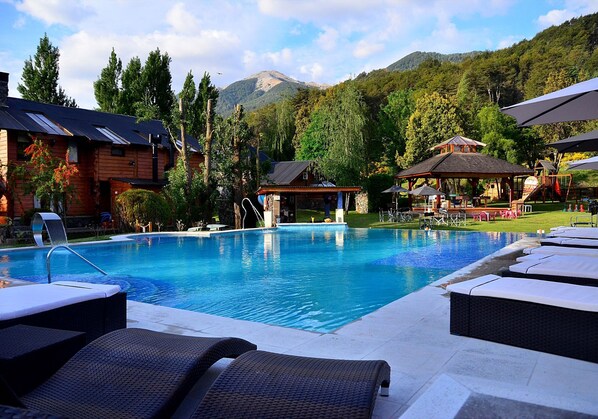 Piscine couverte, piscine extérieure, parasols de plage, chaises longues