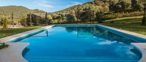 Una piscina al aire libre de temporada, sombrillas