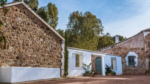 Un edificio de piedra con fachada blanca y una pequeña entrada.