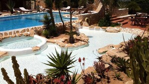 A pool area with lounge chairs, a hot tub, and various plants. - La Rosa Dei Venti (Buggerru)