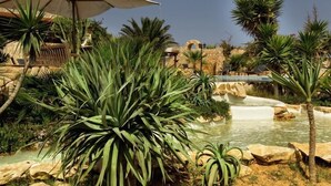 A pool area with water features and tropical plants. - La Rosa Dei Venti (Buggerru)