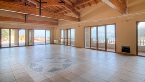 A spacious room with large windows, a wooden ceiling, and a tiled floor. - La Rosa Dei Venti (Buggerru)
