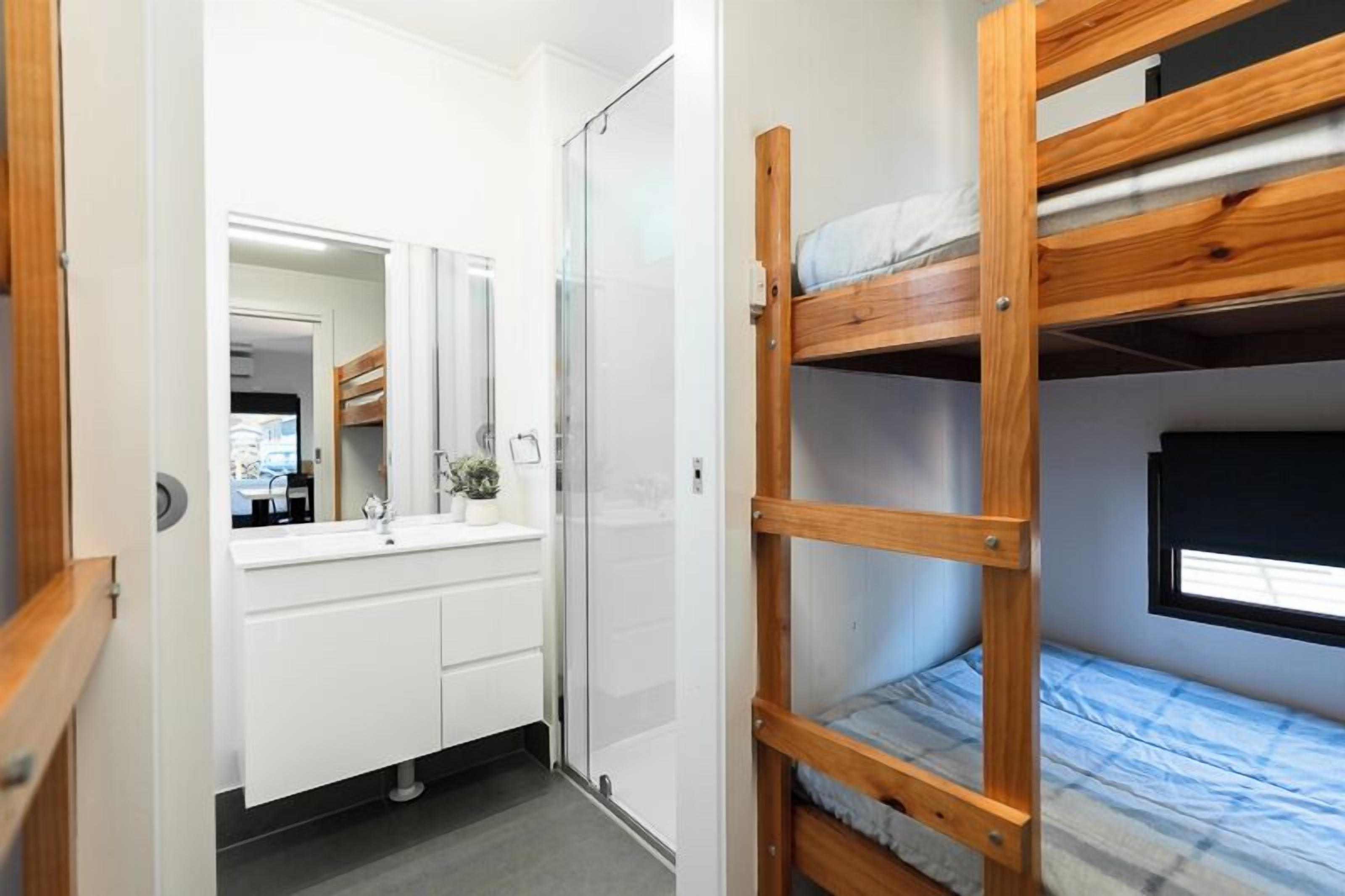 A bunk bed with a wooden frame and a window above it.