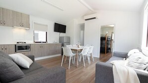 A modern apartment with a kitchen, dining area, and living room. - Adelaide Caravan Park (Hackney)