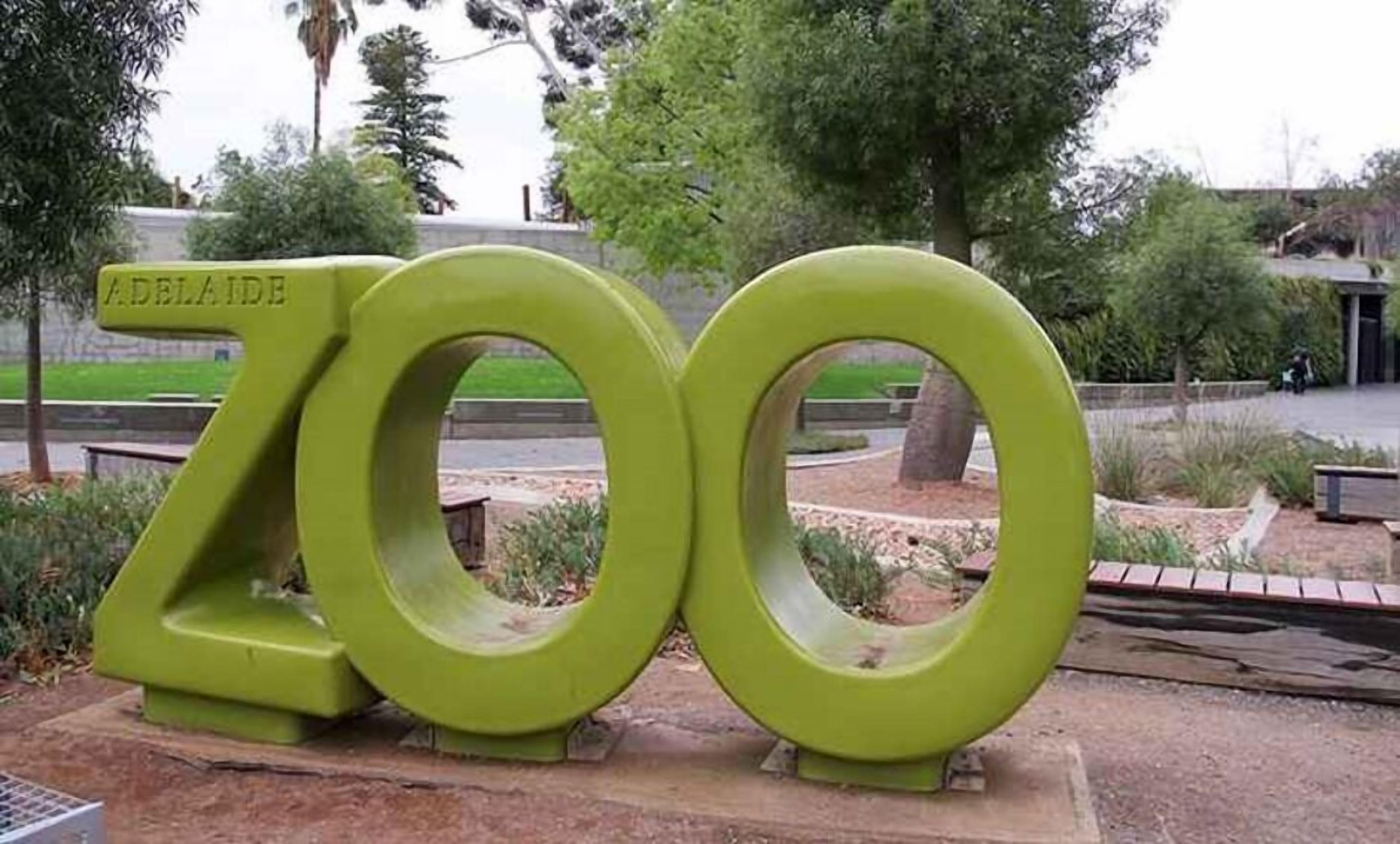 A large green sculpture with the number 700 and the word 'Adelaide' on it, located in a park setting.