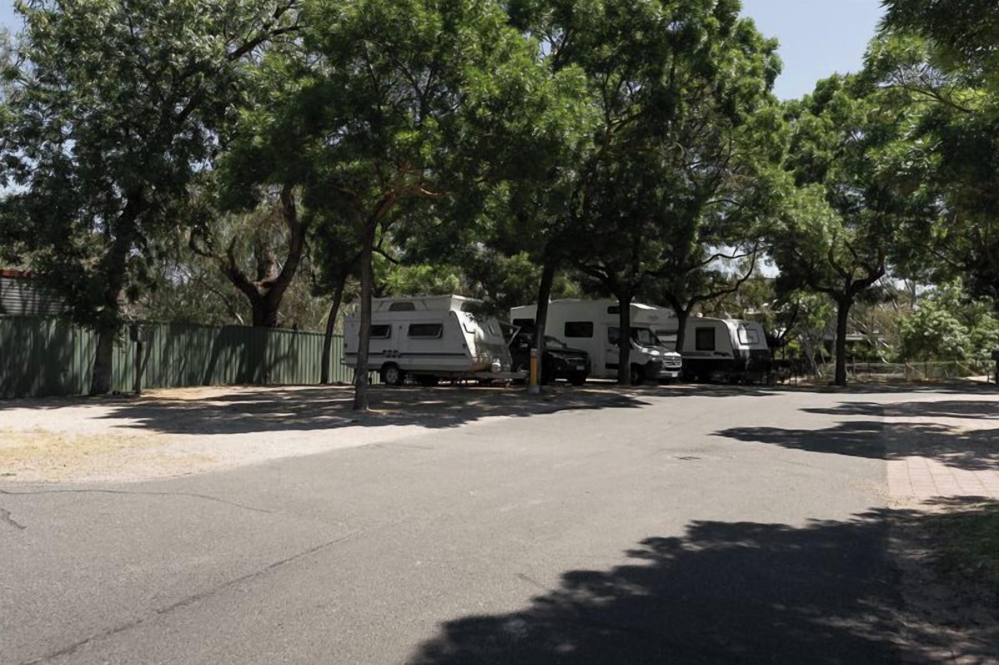 A campground with RVs parked under trees.