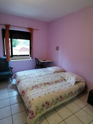Un dormitorio con una cama, un escritorio y una silla.