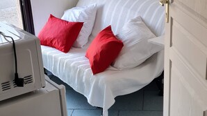 A room with a bed, a white heater, and a door. - Auberge de l'Europe (Saint-Quentin-Fallavier)