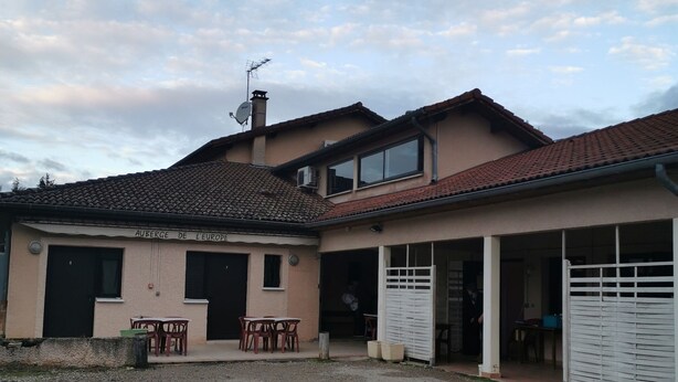 A two-story house with a gravel driveway, a covered patio area, and a garage. - Auberge de l'Europe (Saint-Quentin-Fallavier)