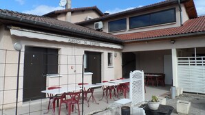 A building with a tiled roof, a sign reading "Auberge de Leurope," and outdoor seating with tables and chairs. - Auberge de l'Europe (Saint-Quentin-Fallavier)