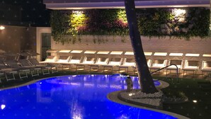 A pool area with lounge chairs and a wall of greenery. - Bellavista (Giugliano in Campania)