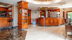 A spacious lobby with a marble floor, wooden reception desk, and a chandelier. - Bellavista (Giugliano in Campania)