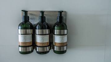 Three bottles of citrus & lemongrass shampoo, liquid soap, and conditioner.