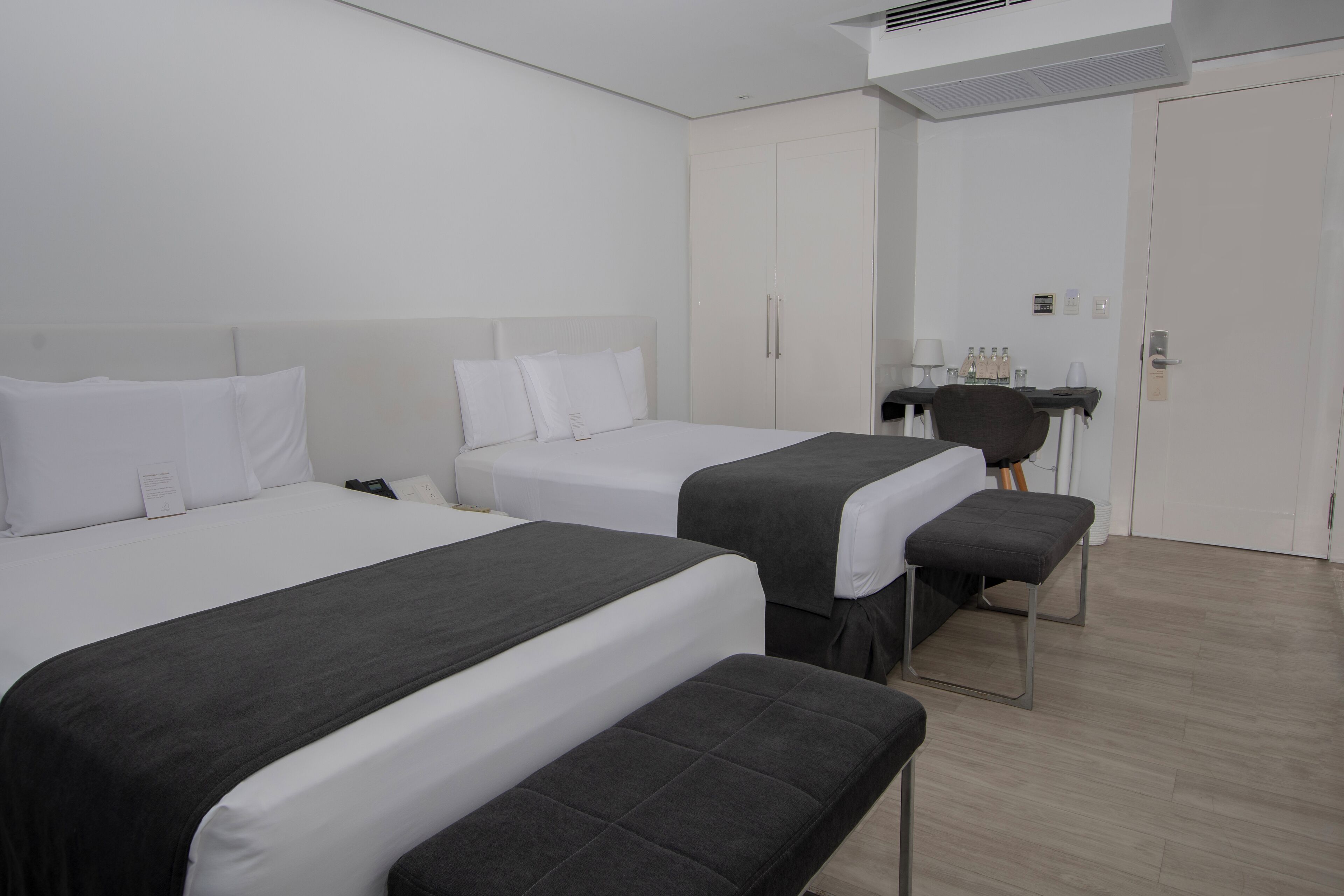 Una habitación de hotel con dos camas, un escritorio y una silla.