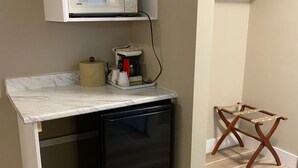 A compact kitchenette with a microwave, coffee maker, and a small refrigerator. - Imperial Motel (100 Mile House)