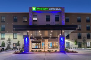 A Holiday Inn Express & Suites building with a covered entrance, stone pillars, and a sign above. - Holiday Inn Express & Suites Fort Worth West by IHG (Fort Worth)