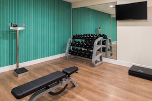 A gym with a bench, dumbbells, and a mirror. - Holiday Inn Express & Suites Fort Worth West by IHG (Fort Worth)