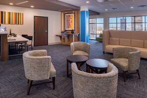 A modern lounge area with seating, a reception desk, and a large window providing a view. - Holiday Inn Express & Suites Fort Worth West by IHG (Fort Worth)