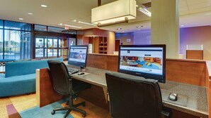 A modern office space with cubicles, a blue sofa, and large windows. - Fairfield Inn & Suites Dunn I-95 (Dunn)