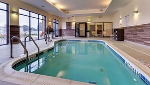 An indoor swimming pool with clear water, a lifeguard chair, and a pool ladder. - Fairfield Inn & Suites Dunn I-95 (Dunn)