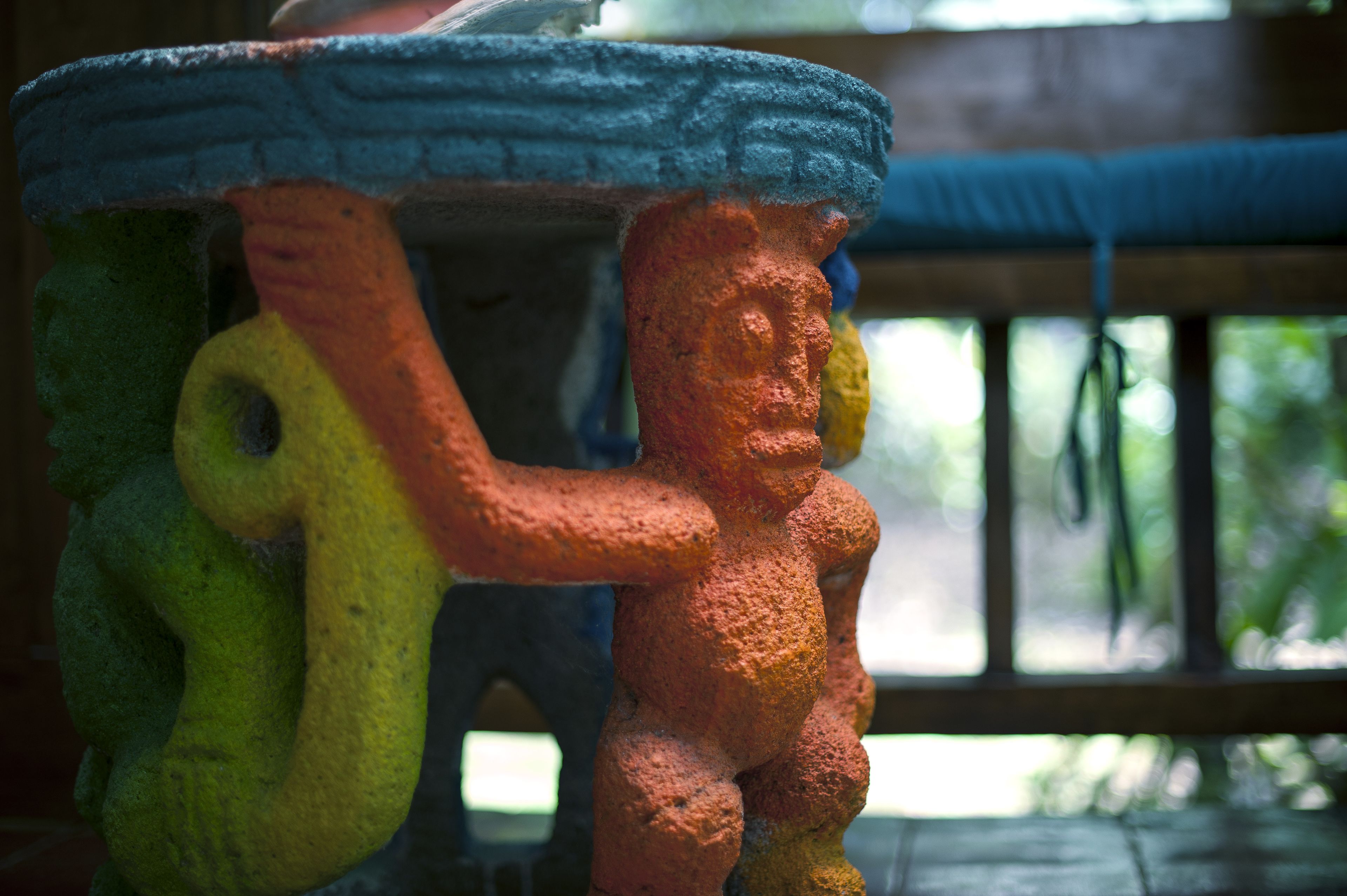 A colorful sculpture of a figure with a blue top hat and a yellow hat.